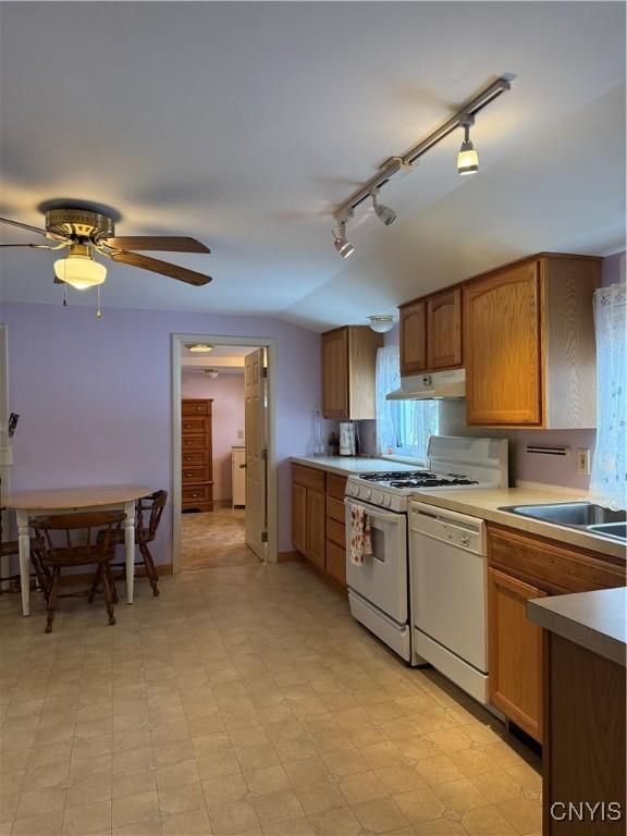 kitchen featuring ceiling fan, sink, and white appliances