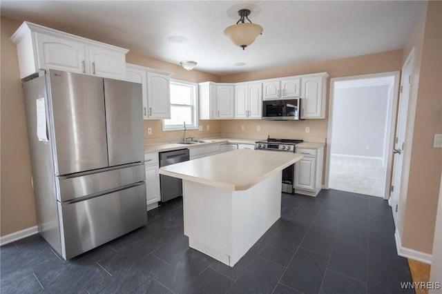 kitchen featuring a center island, sink, stainless steel appliances, and white cabinetry