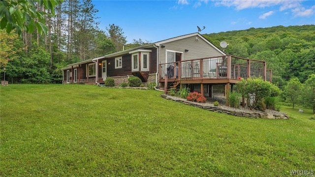 back of house with a deck and a lawn