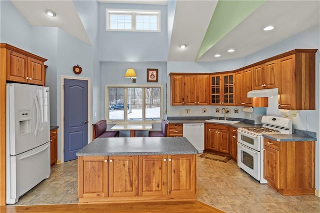 kitchen featuring high vaulted ceiling, sink, white appliances, and a kitchen island