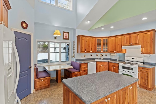 kitchen featuring a kitchen island, sink, high vaulted ceiling, and white appliances