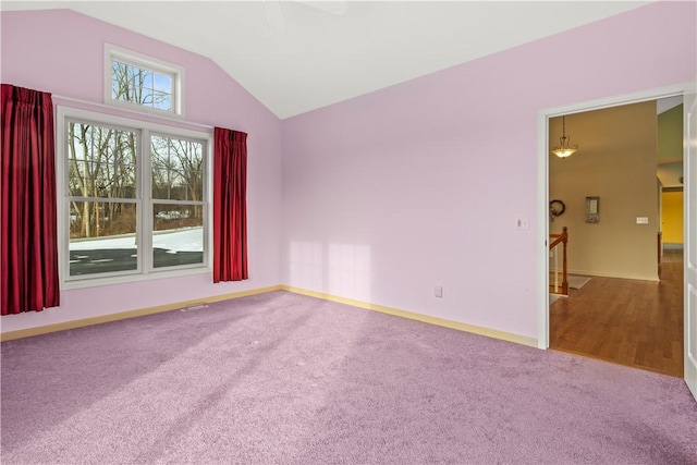 empty room featuring carpet flooring and vaulted ceiling