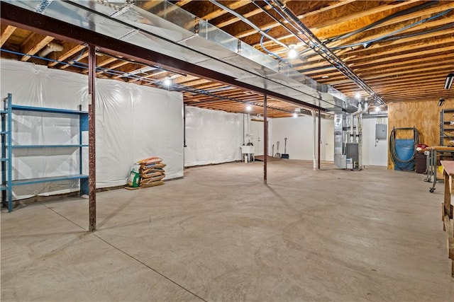 basement featuring heating unit, sink, and electric panel