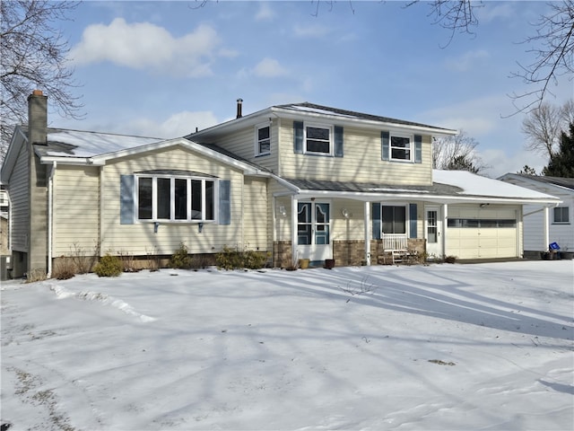 view of property with covered porch and a garage