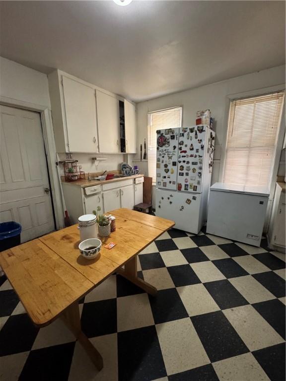 kitchen featuring white cabinets and white fridge