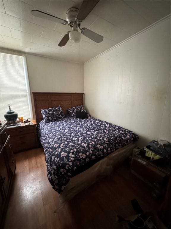 bedroom with hardwood / wood-style floors, ornamental molding, and ceiling fan