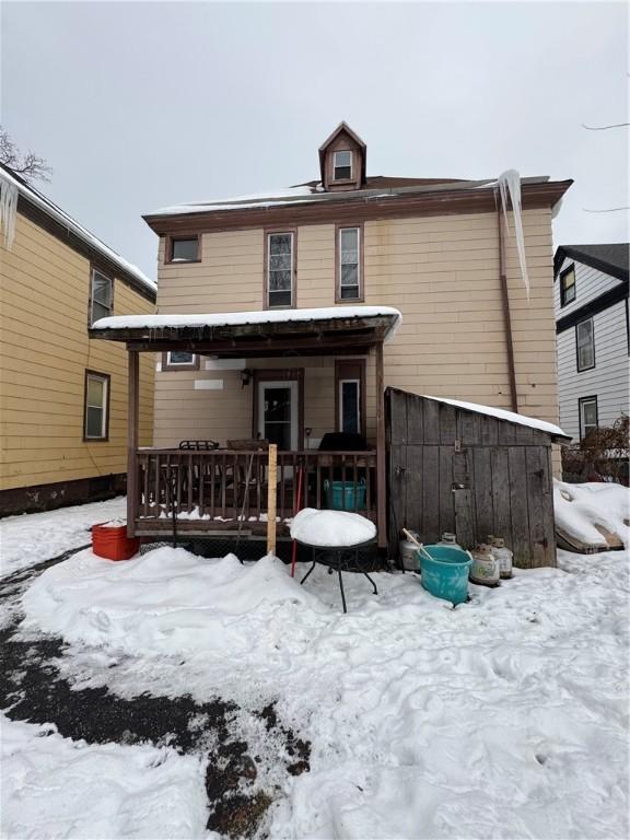 view of snow covered back of property