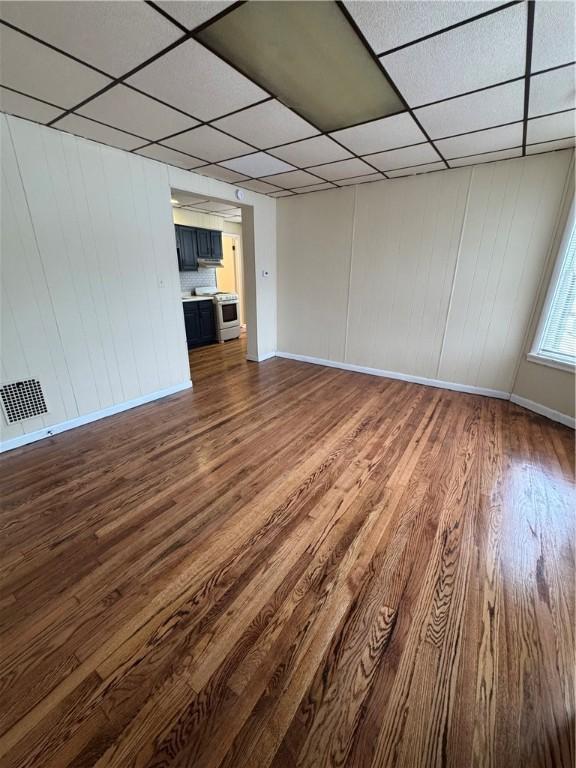 empty room featuring hardwood / wood-style flooring and a paneled ceiling