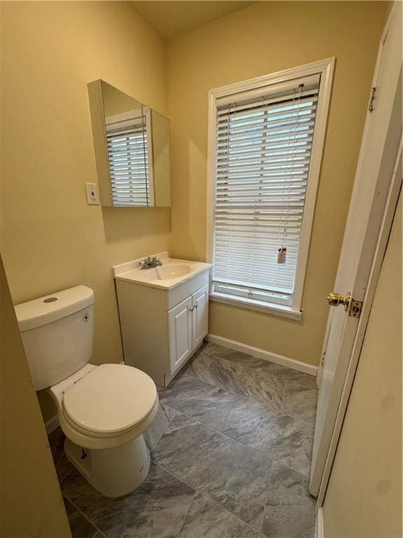 bathroom with vanity, a wealth of natural light, and toilet