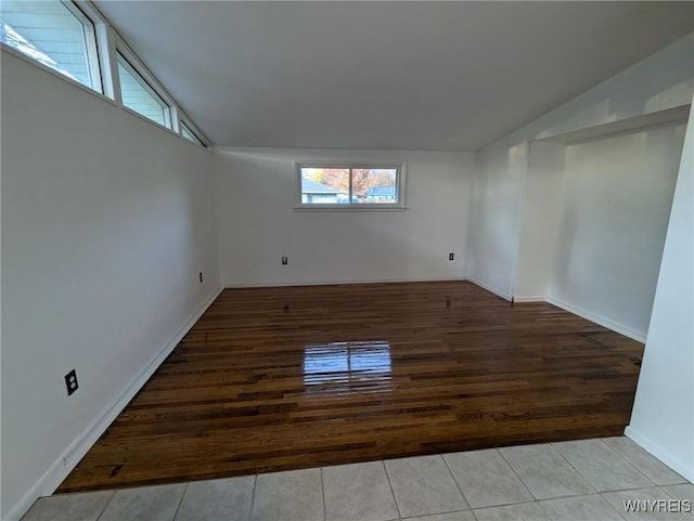 tiled spare room with lofted ceiling