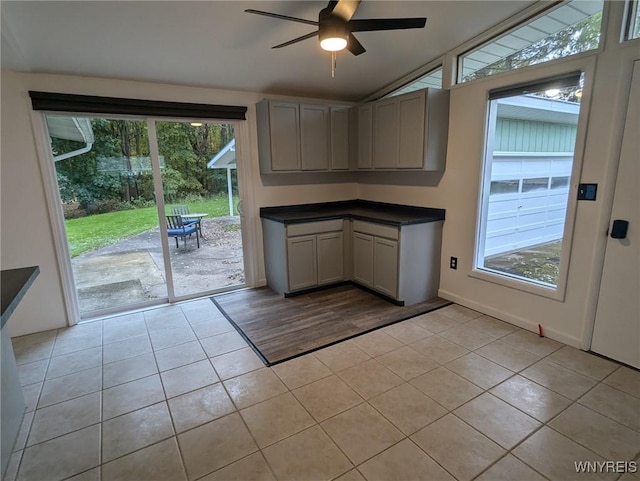 kitchen with lofted ceiling, ceiling fan, light tile patterned floors, and gray cabinetry