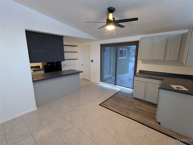 kitchen with ceiling fan, light tile patterned floors, gray cabinetry, and vaulted ceiling