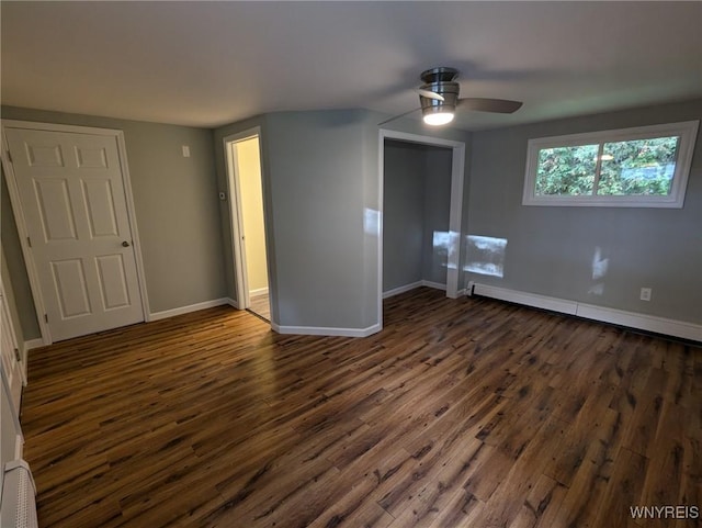 unfurnished bedroom featuring ceiling fan, baseboard heating, and dark hardwood / wood-style floors