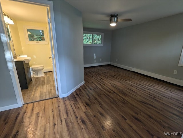 unfurnished room with ceiling fan, sink, and dark hardwood / wood-style floors