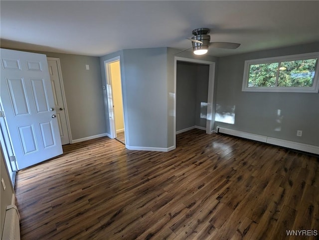 unfurnished room featuring ceiling fan, dark wood-type flooring, and a baseboard heating unit