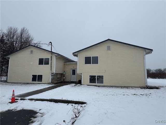 view of snow covered back of property