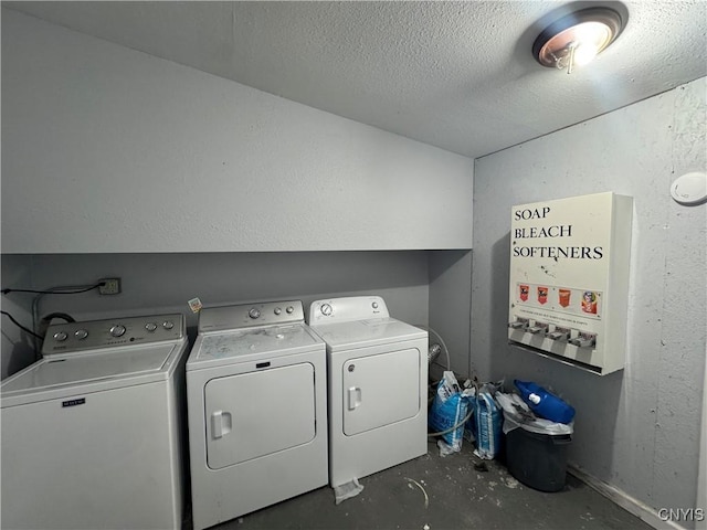 washroom with washing machine and clothes dryer and a textured ceiling