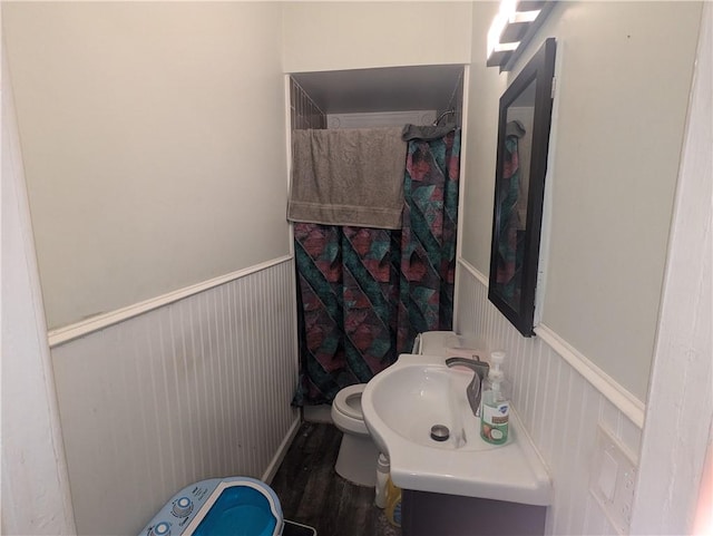 411 Bay St, Rochester, NY 14605 - full bathroom featuring toilet, a sink, a shower with curtain, a wainscoted wall, and wood finished floors
