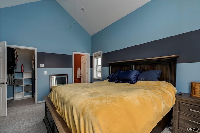 bedroom featuring carpet floors, high vaulted ceiling, and a walk in closet