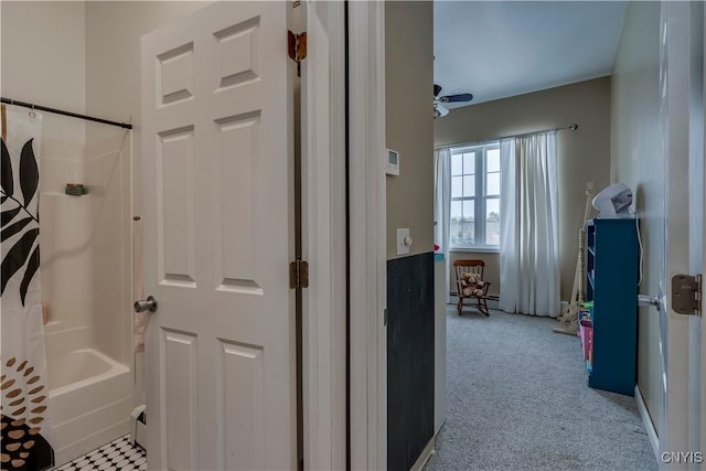 interior space featuring ceiling fan, shower / bath combo, and a baseboard radiator