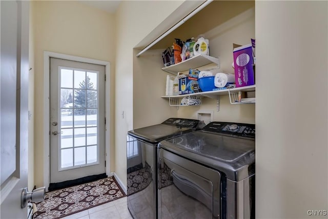 clothes washing area featuring light tile patterned floors and washing machine and clothes dryer