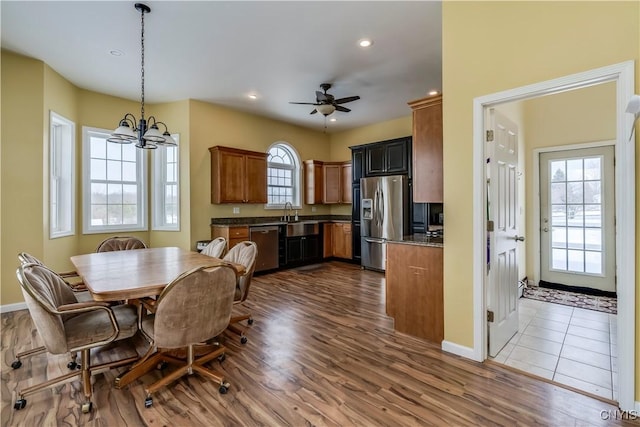 dining room with wood-type flooring, sink, and ceiling fan with notable chandelier