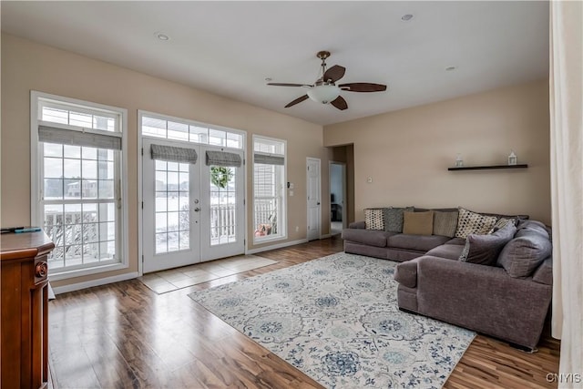 living room featuring ceiling fan, french doors, and light hardwood / wood-style flooring