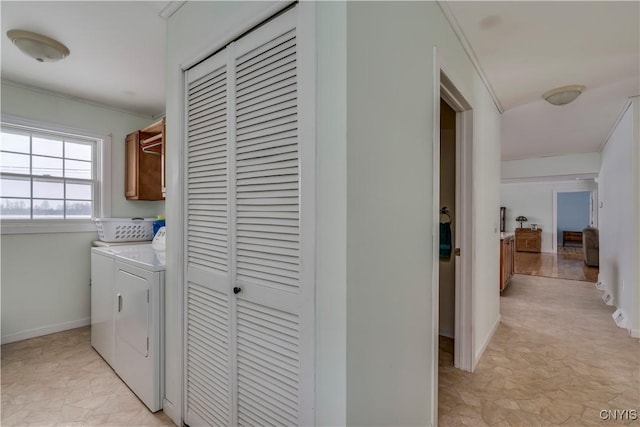 laundry room featuring cabinets, washer and clothes dryer, and ornamental molding