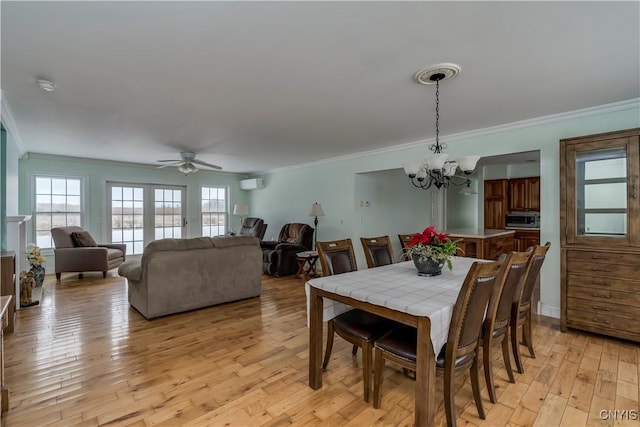 dining room featuring a wall mounted air conditioner, ceiling fan with notable chandelier, ornamental molding, and light hardwood / wood-style flooring