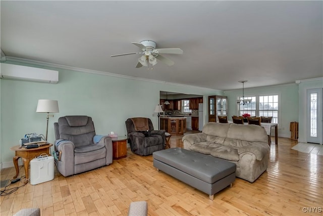 living room featuring ceiling fan with notable chandelier, light hardwood / wood-style flooring, crown molding, and a wall mounted AC