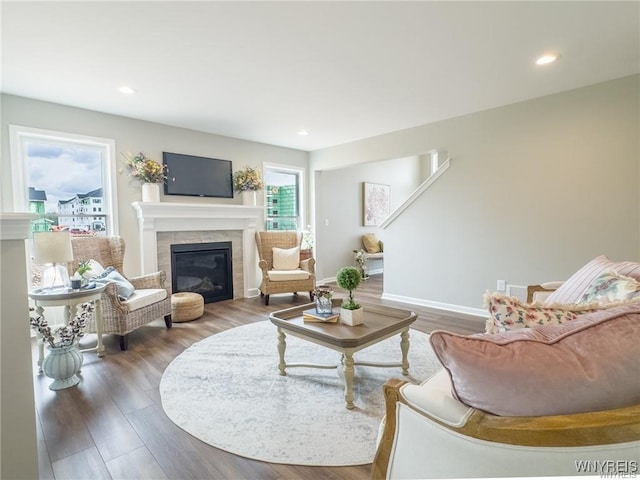 living room with dark wood-type flooring and a tiled fireplace