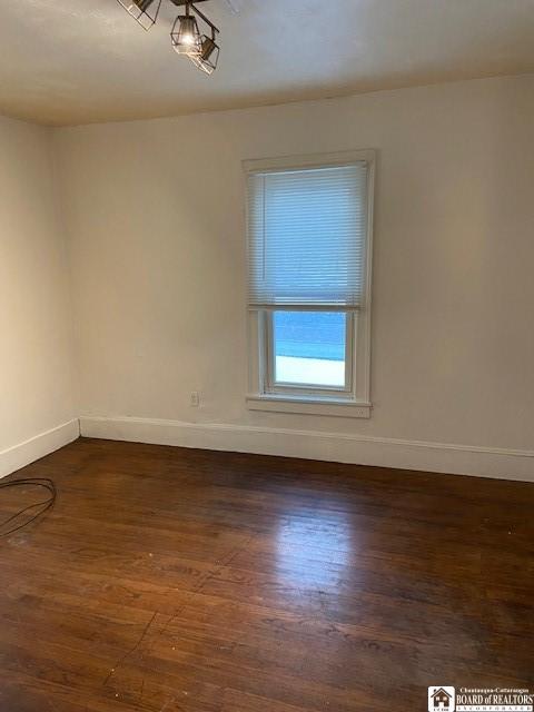 spare room featuring dark wood-type flooring