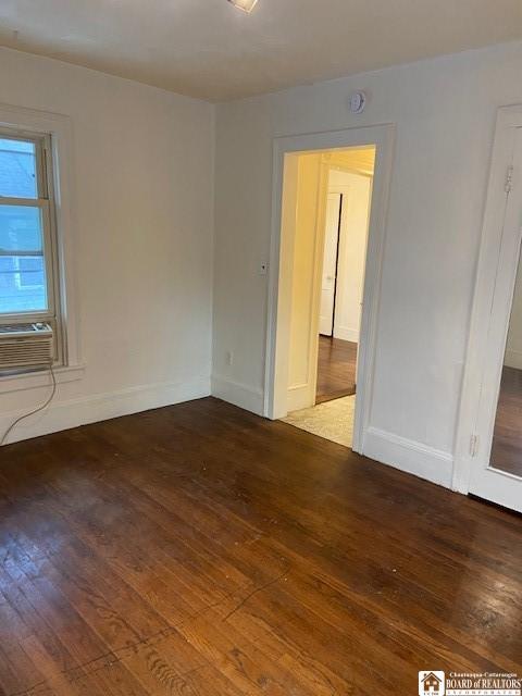 empty room featuring cooling unit and wood-type flooring