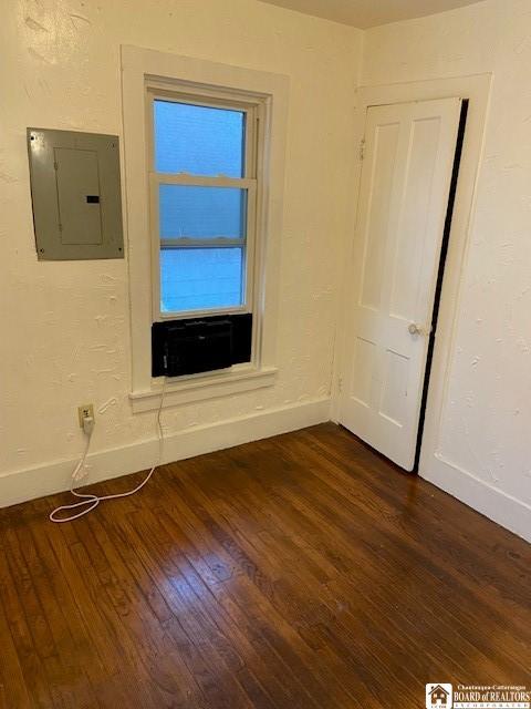 unfurnished room with dark wood-type flooring and electric panel