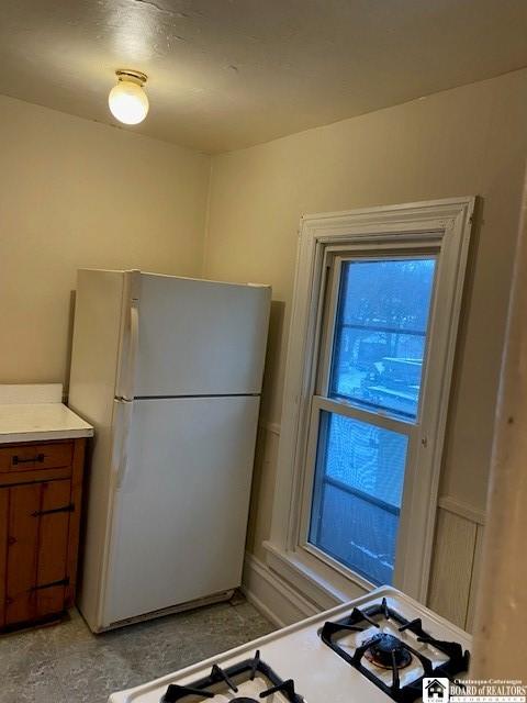 kitchen featuring stove and white fridge