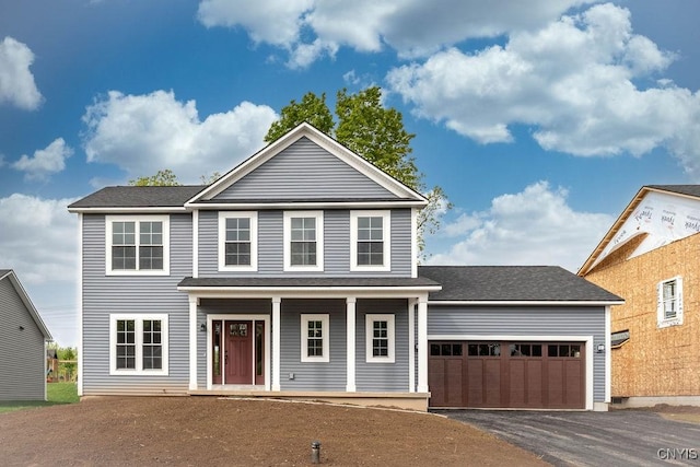 view of front property featuring covered porch and a garage