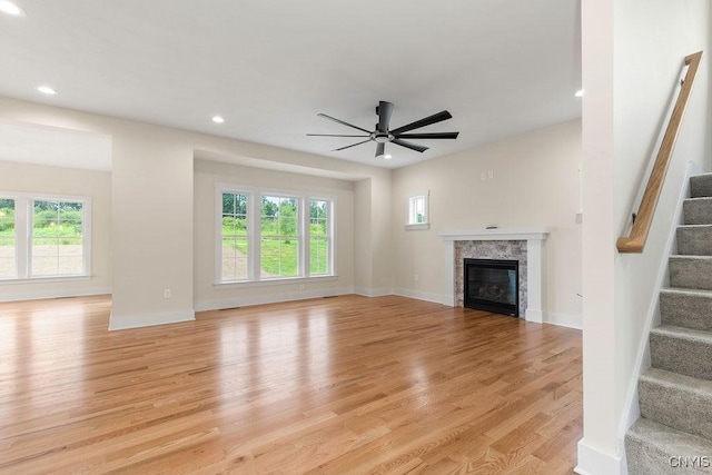 unfurnished living room with light wood-type flooring and ceiling fan