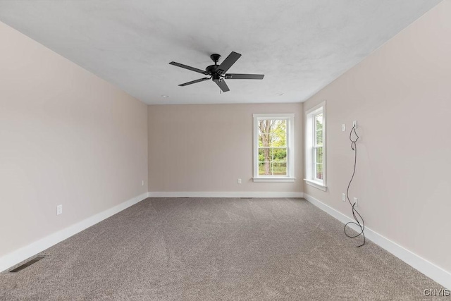 carpeted spare room featuring ceiling fan