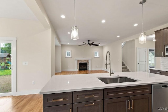 kitchen featuring pendant lighting, dark brown cabinetry, appliances with stainless steel finishes, sink, and ceiling fan