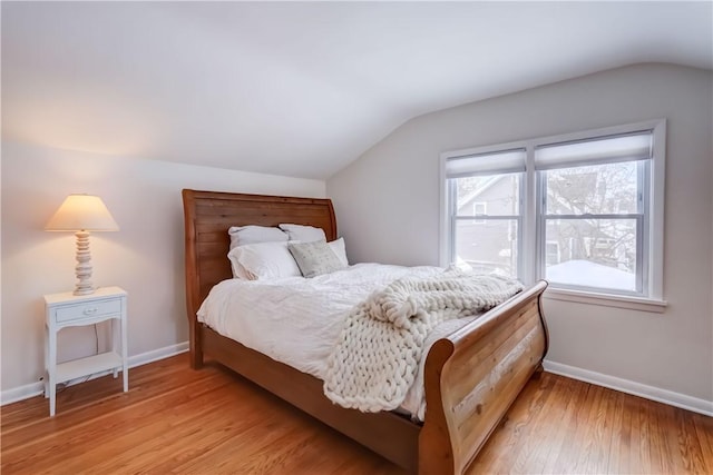 bedroom with light wood-type flooring and lofted ceiling