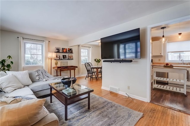 living room with light hardwood / wood-style flooring and sink