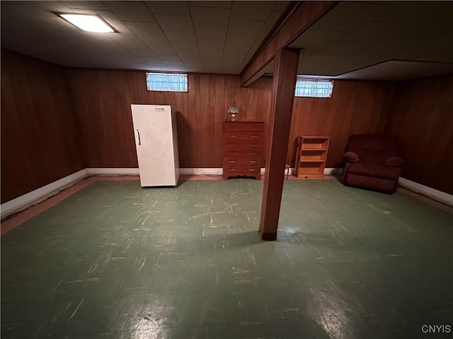 basement featuring a healthy amount of sunlight and wooden walls