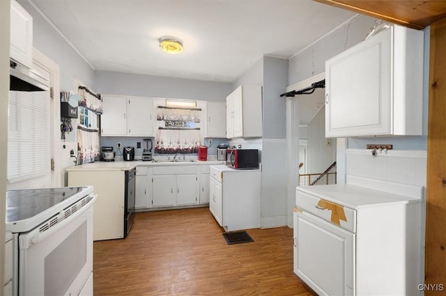 kitchen featuring stainless steel dishwasher, electric range, white cabinetry, and light hardwood / wood-style floors