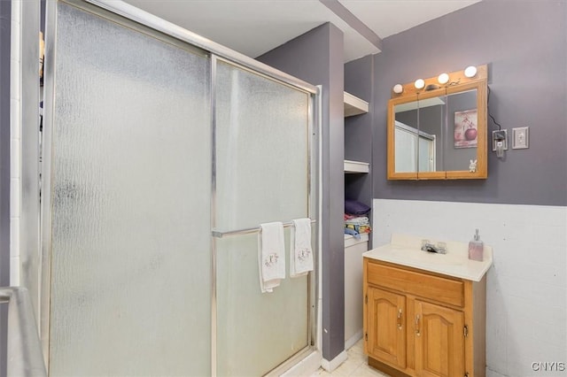 bathroom featuring vanity and a shower with door