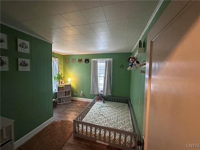 bedroom with dark wood-type flooring and crown molding