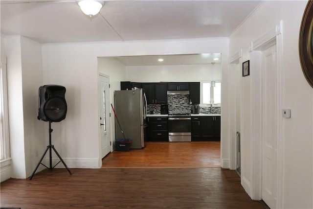 hallway with dark wood-type flooring, crown molding, and sink