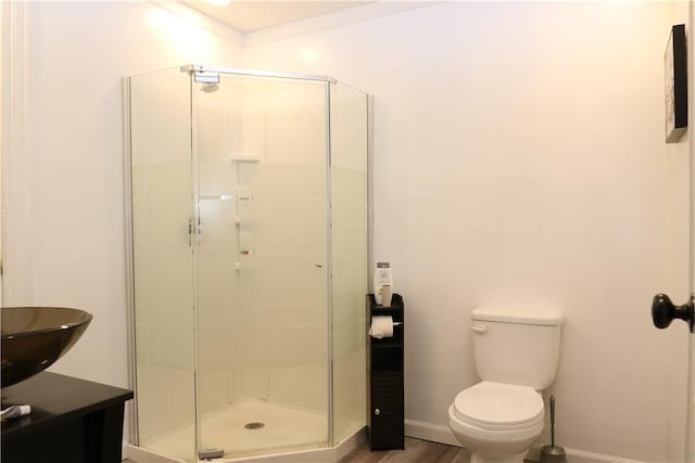 bathroom featuring toilet, crown molding, hardwood / wood-style floors, and walk in shower