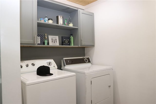 laundry area with washer and dryer and cabinets