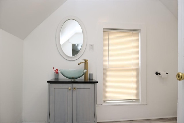 bathroom featuring lofted ceiling and vanity