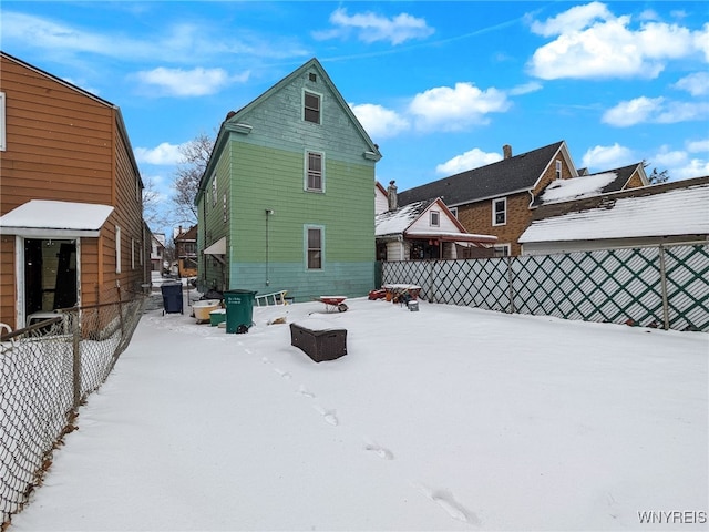 view of snow covered back of property